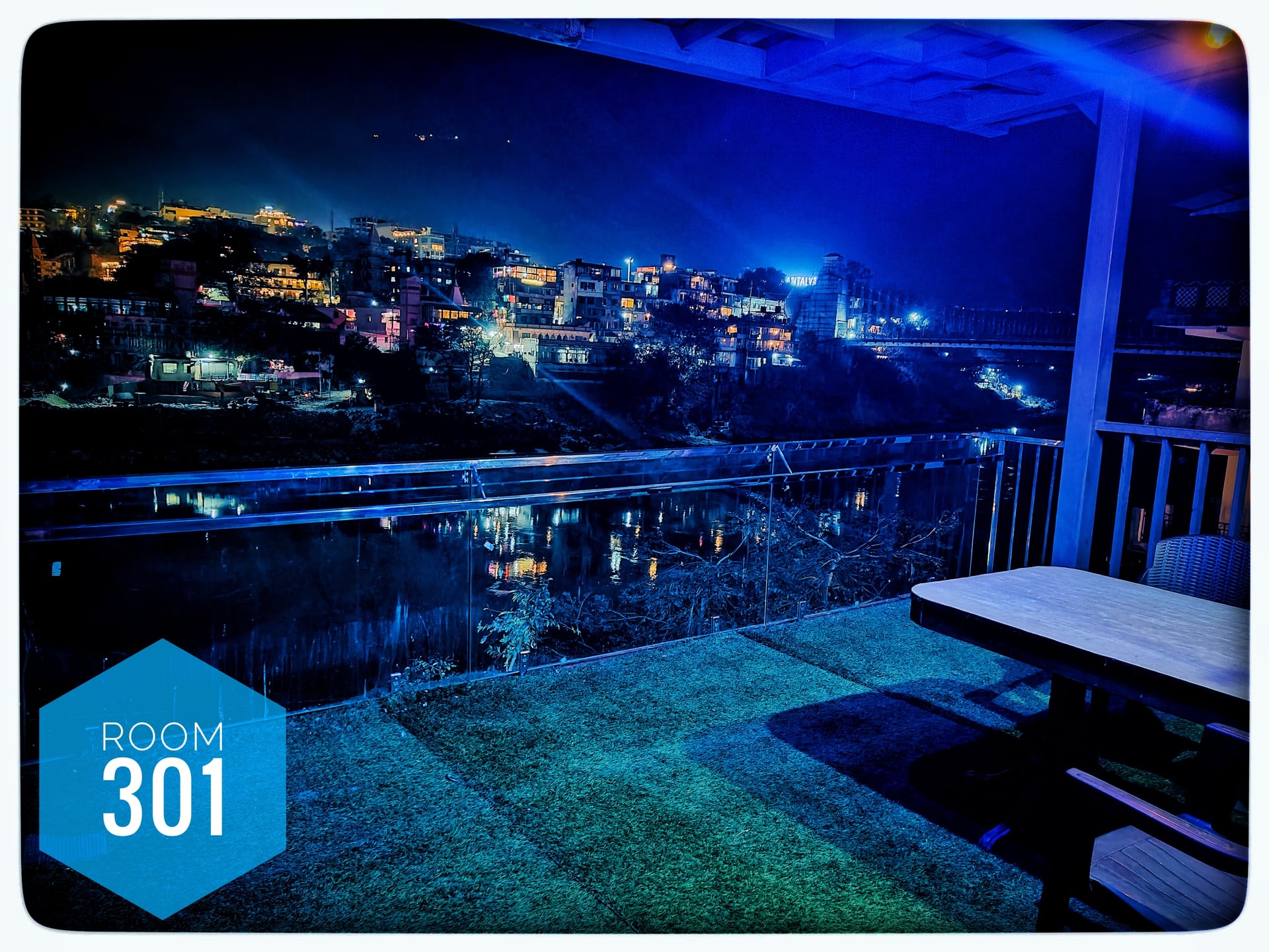 Night view from Room 301 balcony of Hotel Ganga View, Rishikesh. Illuminated Ganga River, city lights, and Laxman Jhula bridge.